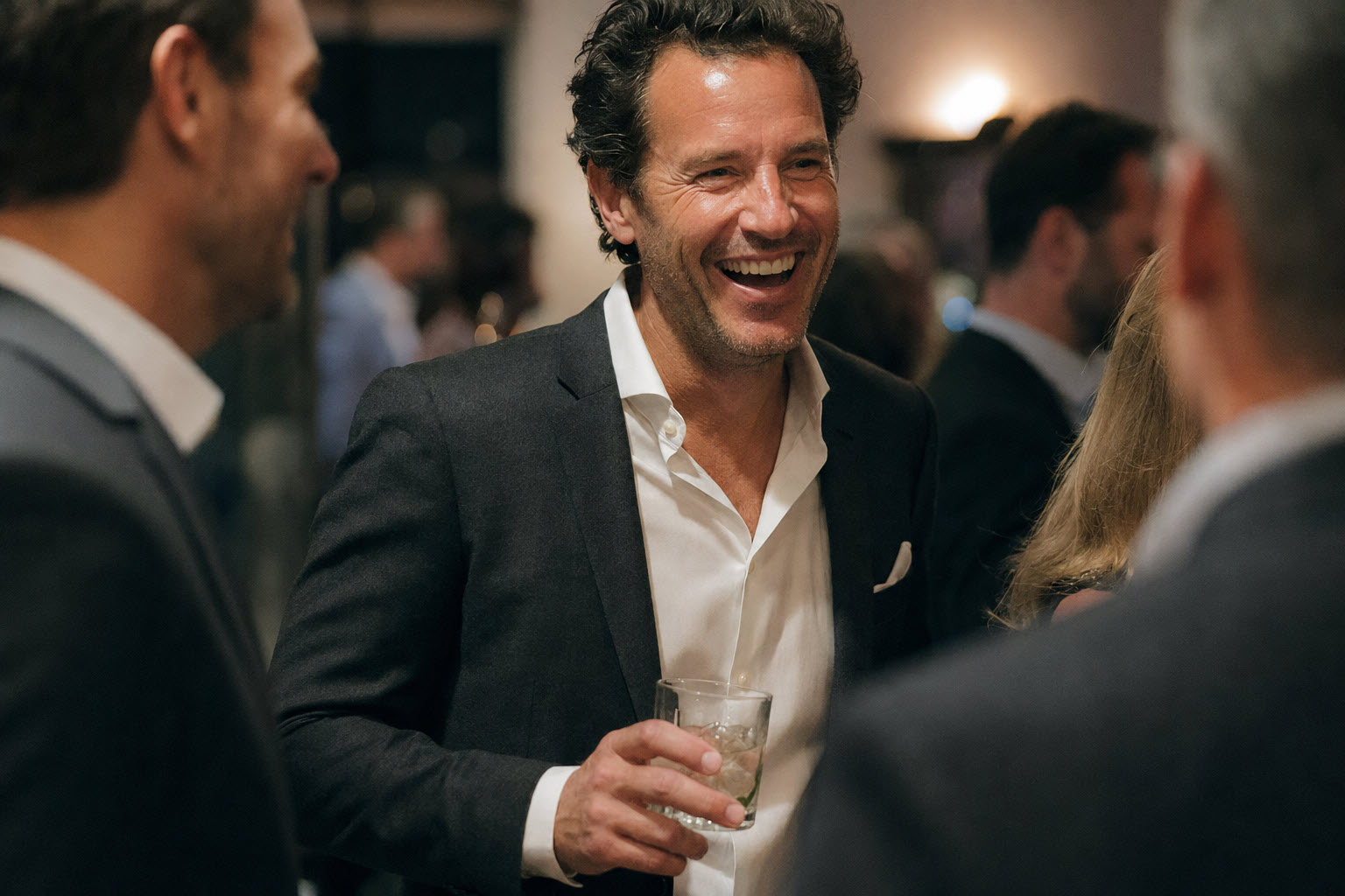 Confident man at a class reunion in a charcoal blazer