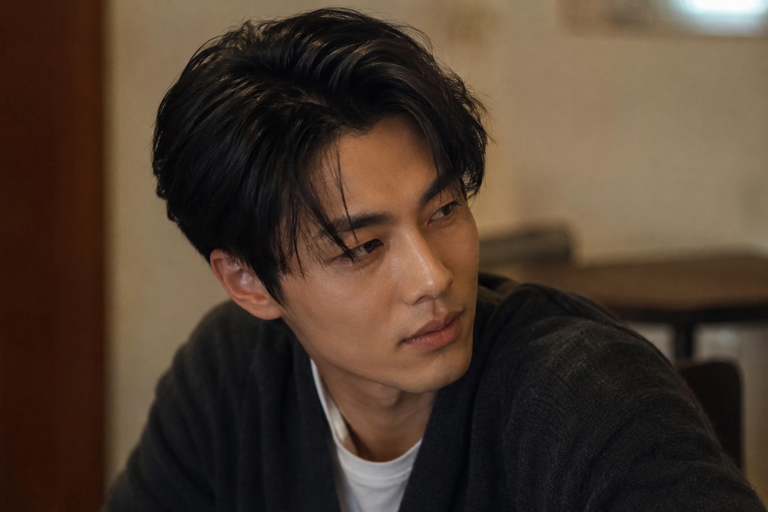 Man with thick, straight black hair styled with volume and a soft side part.