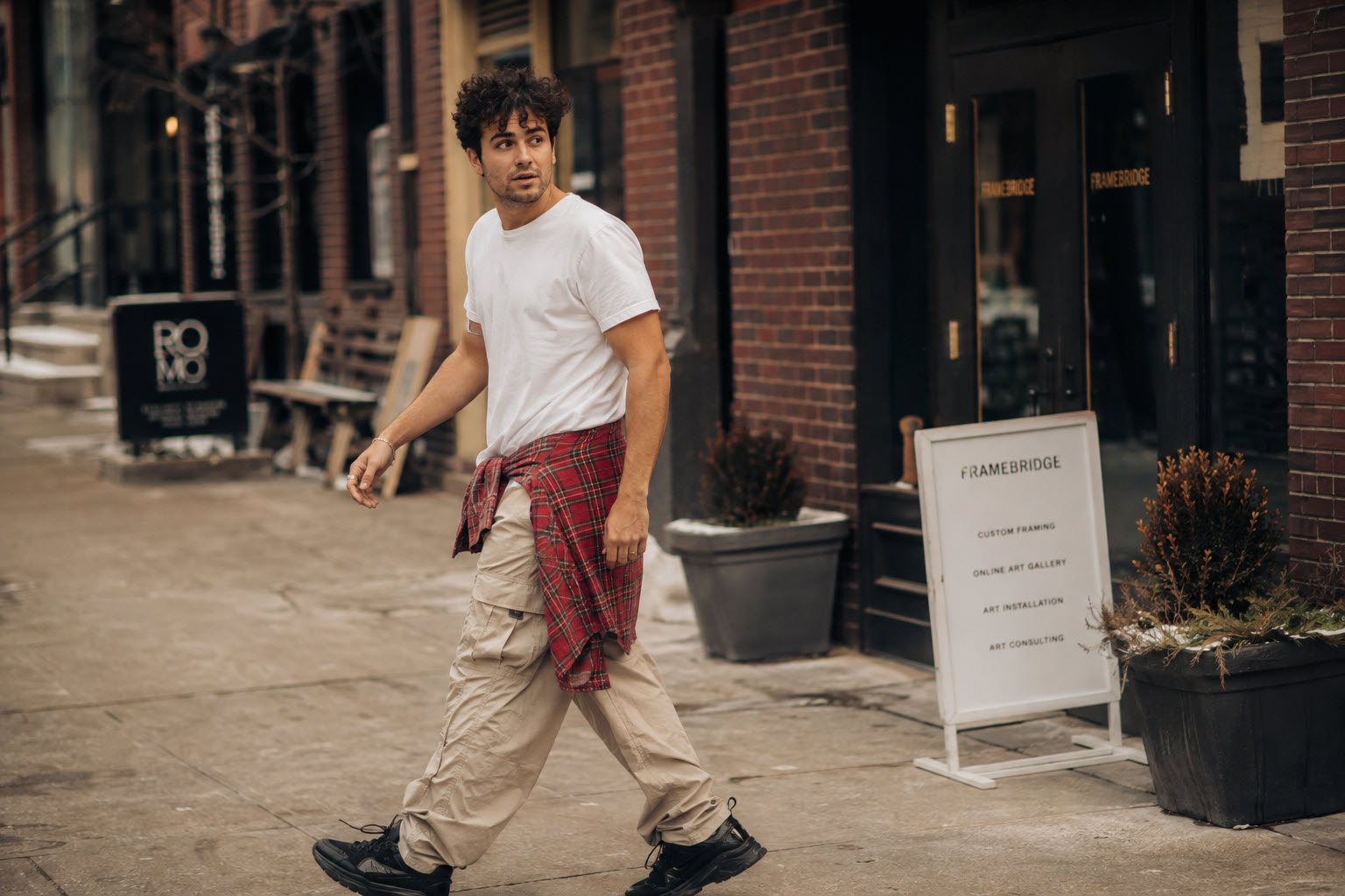 90s cargo outfit: light cargo pants, plain white tee, chunky black sneakers, flannel tied at the waist