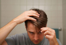 Man massaging hair roots with fingers to activate texture and volume