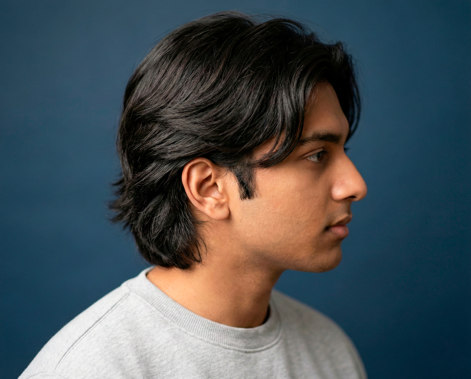 Man with bro flow hairstyle featuring medium-length layered hair styled naturally with relaxed movement.