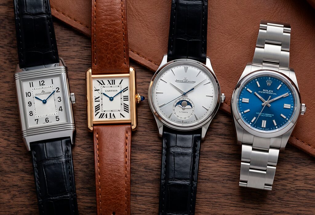 Four classic luxury watches laid out together, including rectangular, moonphase, and steel bracelet styles.